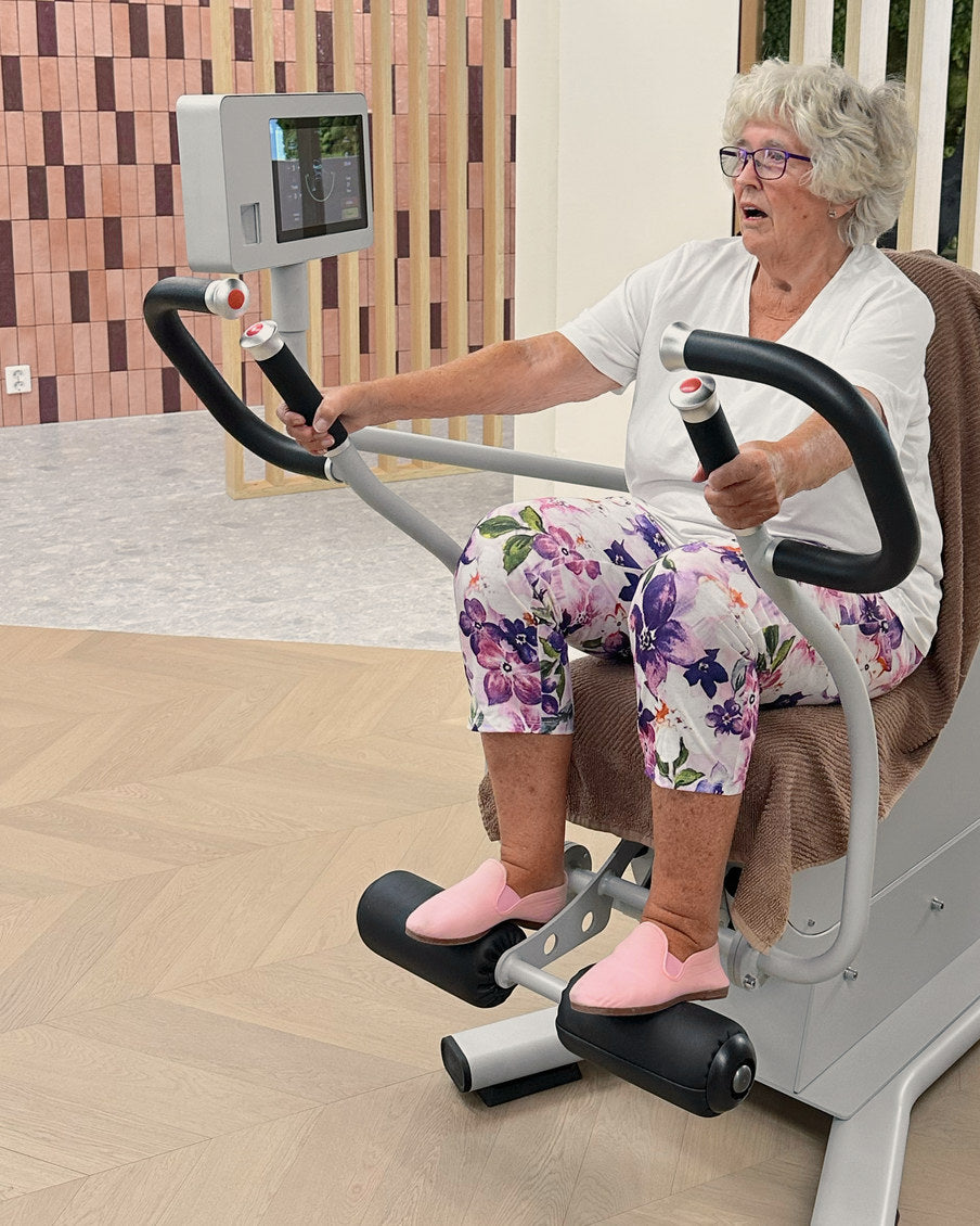 Et medlem i blomstrete tights skyver håndtakene rett fram i brystpress- og roingsmaskinen.